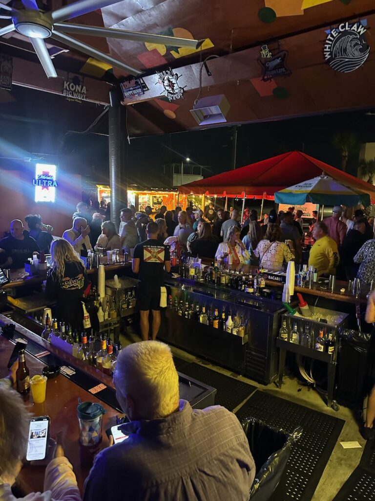 Evening crowd at the lit back bar at Ricky T's
