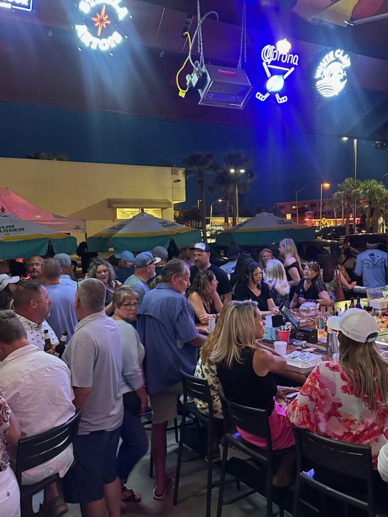Night crowd under neon signs at Ricky T's